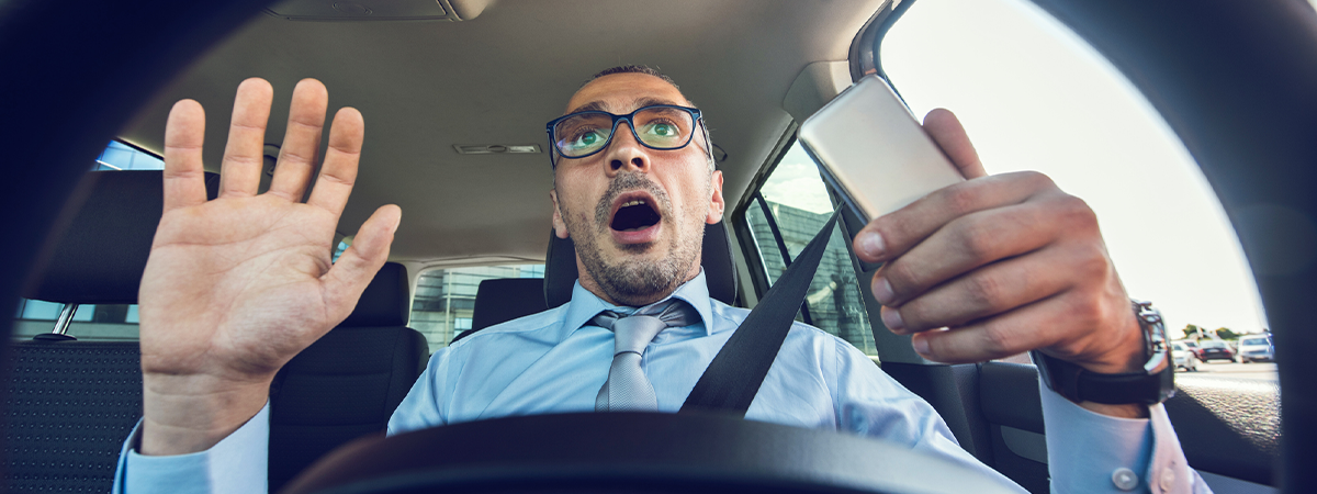 Distracted driver with phone in his hands