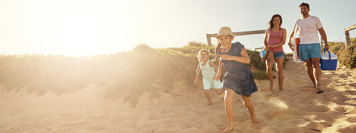 Family running onto beach