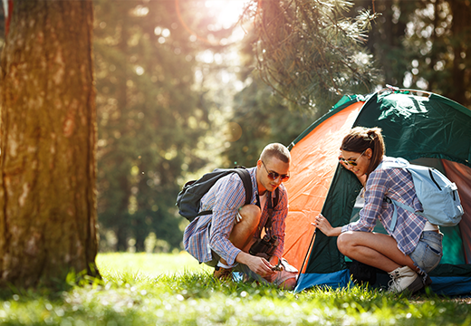 Young couple setting up tent.