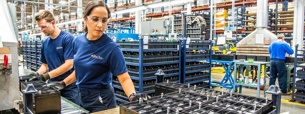 Woman making automotive batteries.