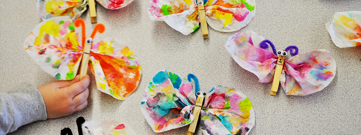 Child holding coffee filter butterflies