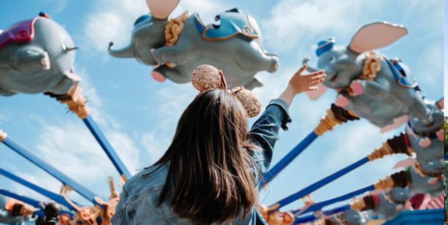 Young girl waving at rides in Disney's Magic Kingdom