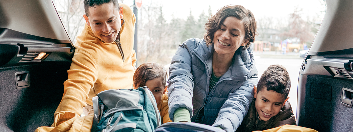 Family loading a car trunk before the road trip