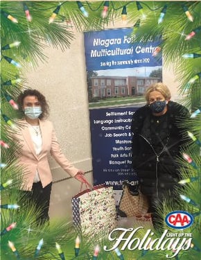 An organizer from the Niagara Folk Arts Multicultural Centre and Mahasti Khoshnoud hold mask donations.