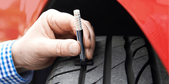 Tread Depth Gauge testing depth on vehicle tire