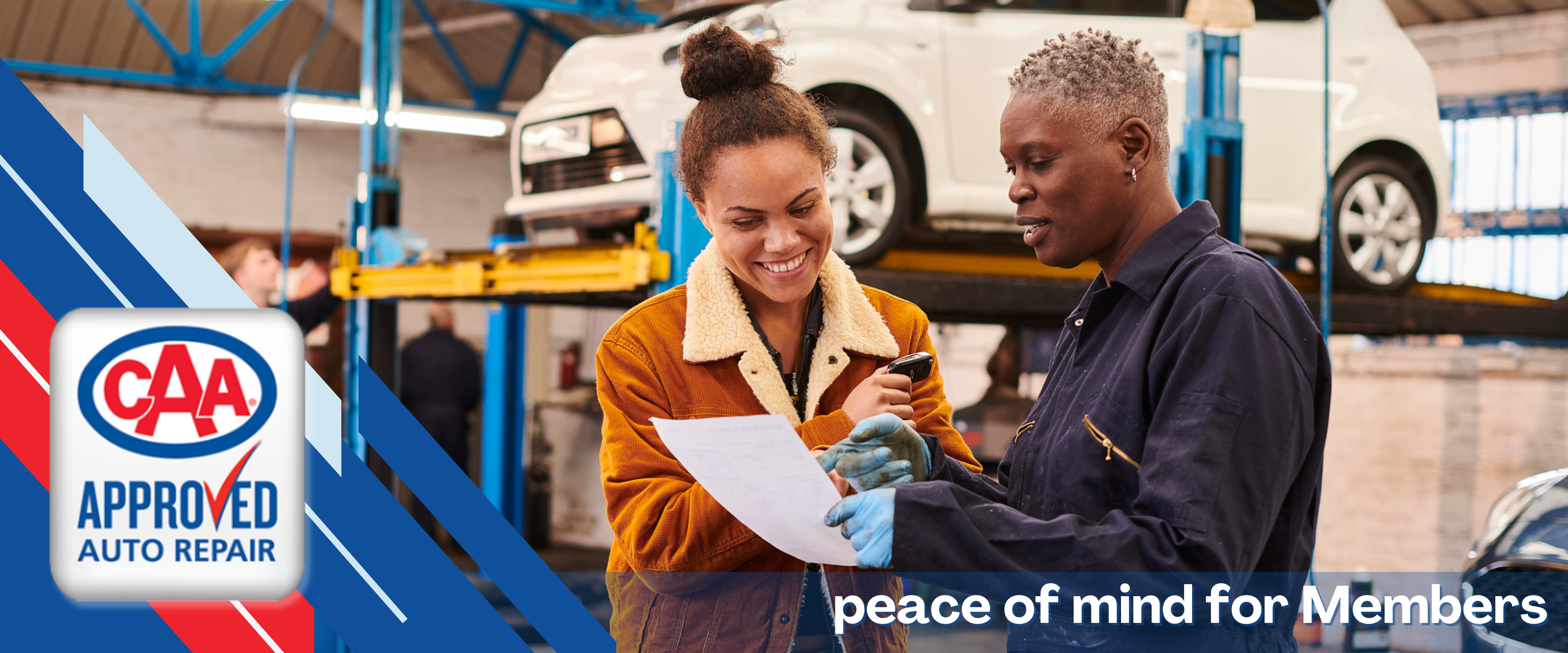 female mechanic is showing a female customer a report of her vehicle inspection, taken in an auto repair shop and both women are happy