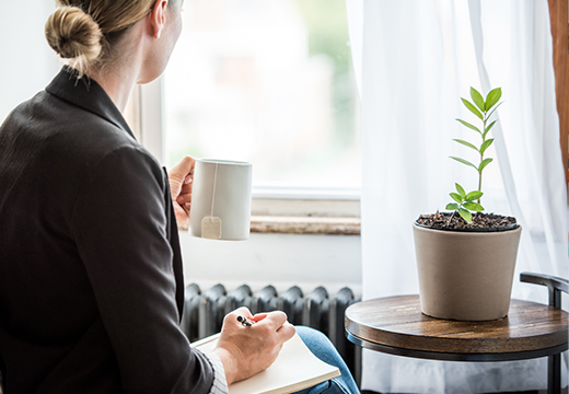 Woman looking out window with tea in hand