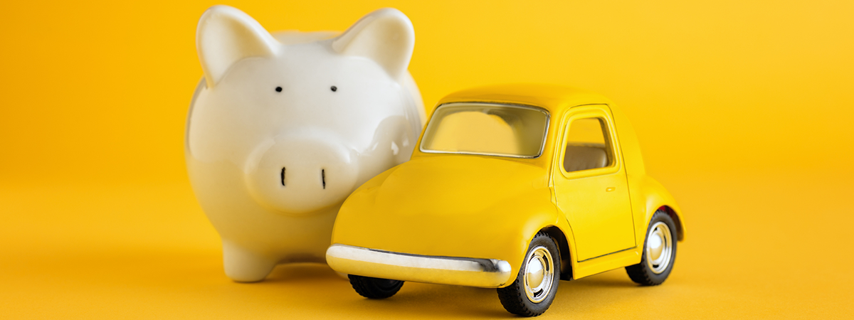 White piggy bank, yellow toy car on yellow background.