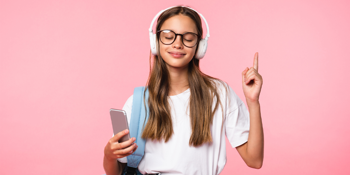 Girl holding phone and listening to headphones