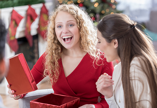 Women opening gifts with excitement.