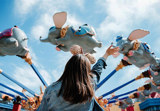 Young girl waving to ride in Disney's Magic Kingdom theme park.