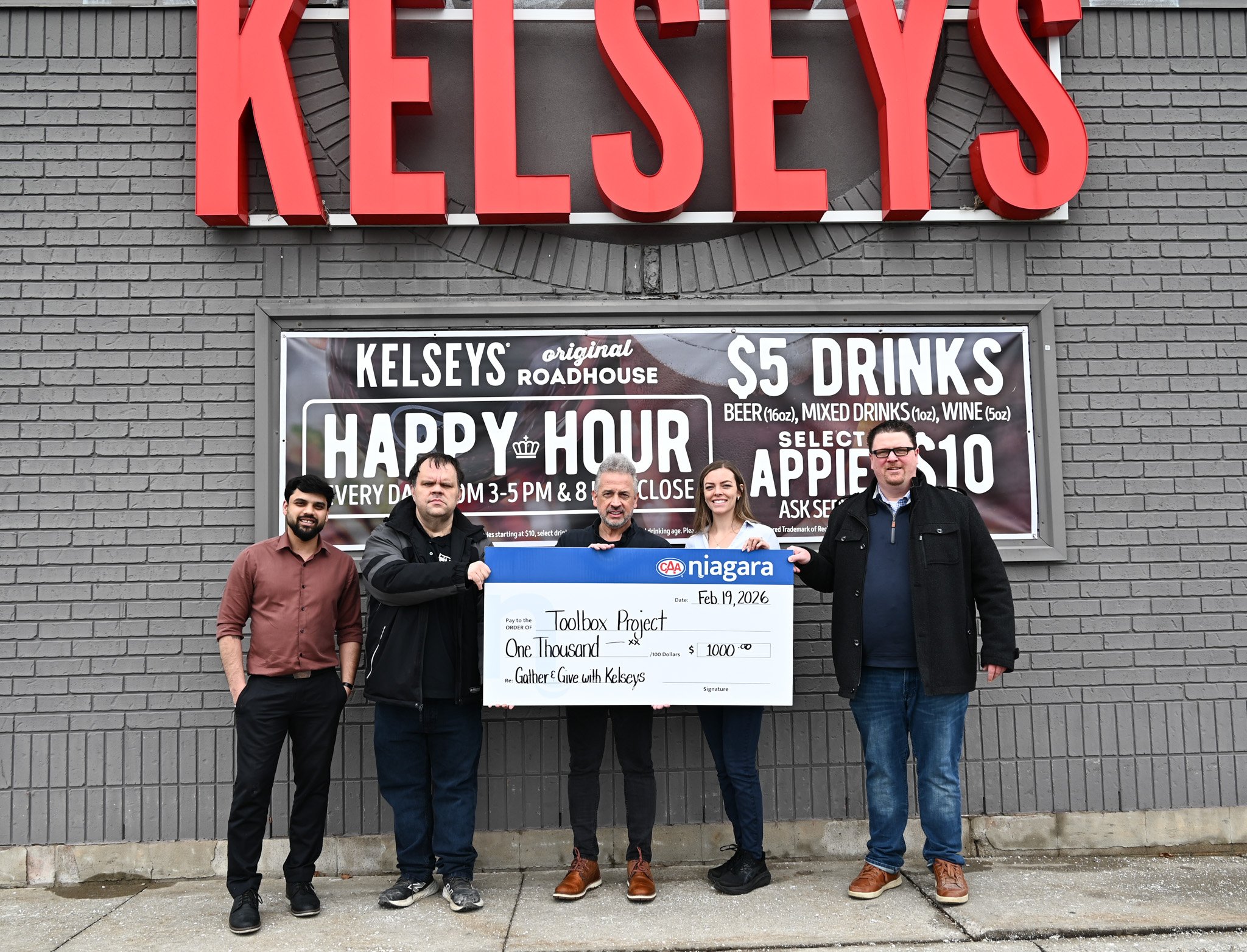 Representatives from Kelseys, CAA Niagara and Toolbox Project pose with large cheque for $1000