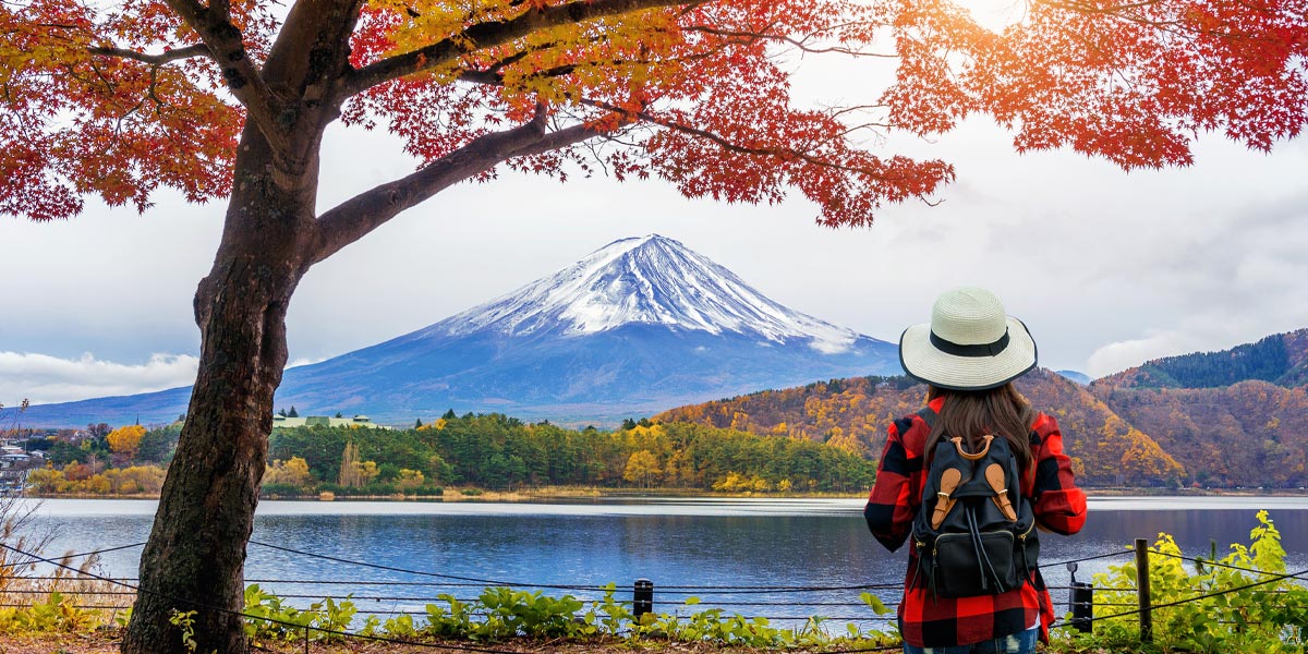 Woman traveler with backpack looking to Fuji mountains in Autumn, Japan. 