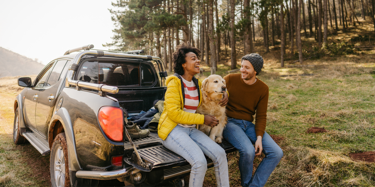 Couple sitting in truck with dog
