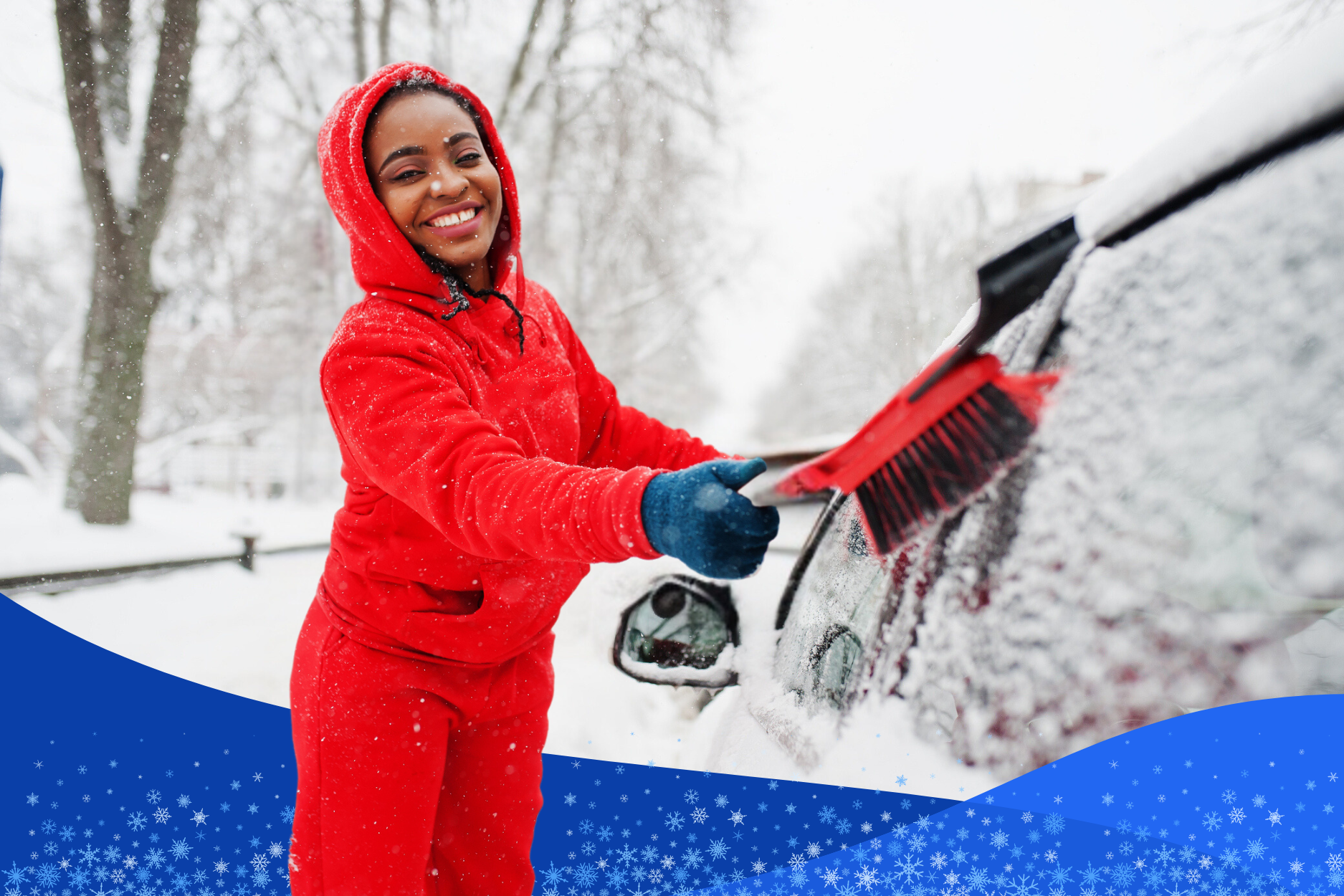 Young woman brushing off her car in the middle of a winter snow fall