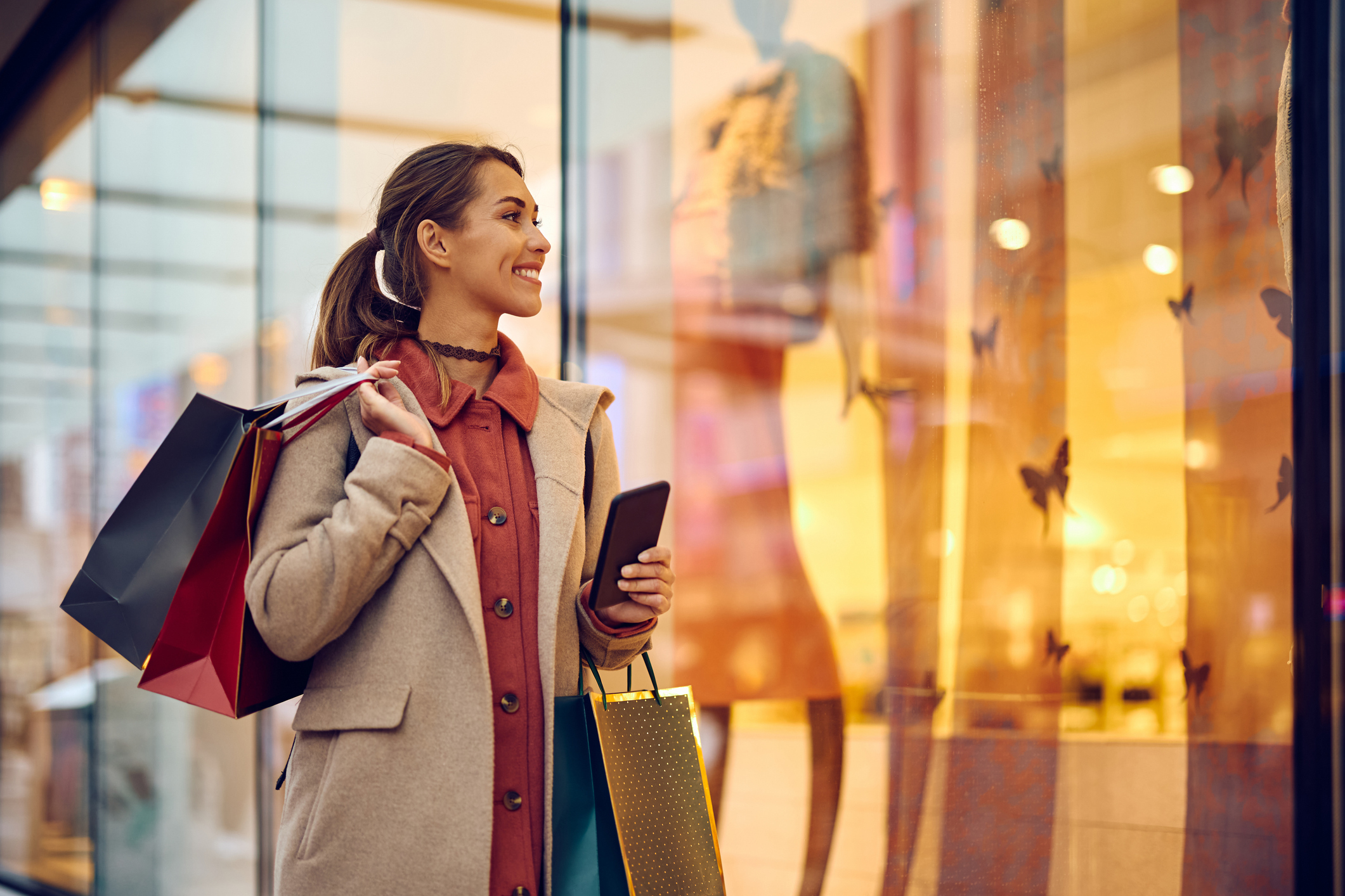 Women holding shopping bag infront of store window
